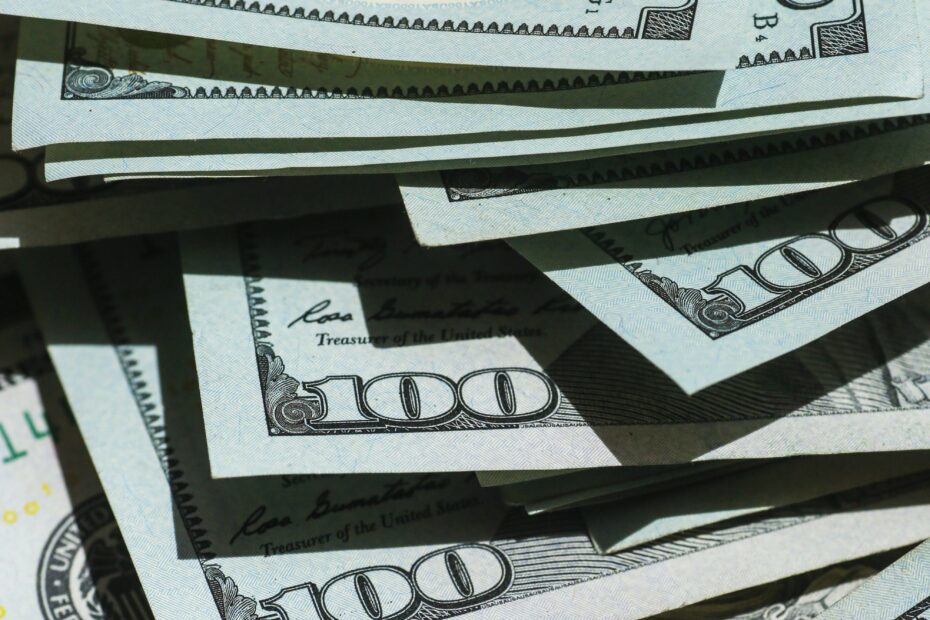 A pile of hundred dollar bills is shown in this photo