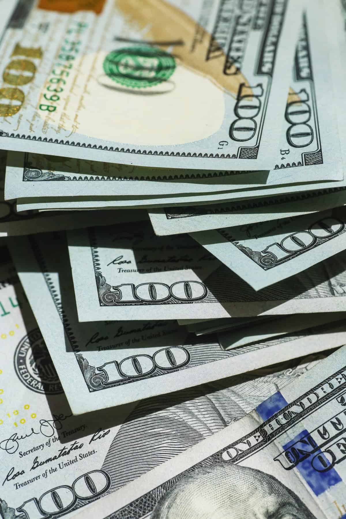 A pile of hundred dollar bills is shown in this photo
